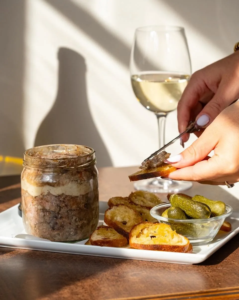 Terrine maison en bocal servie avec pain grillé et cornichons, accompagnée d'un verre de vin blanc, au bar à vin Au 2ème verre à Rouen.