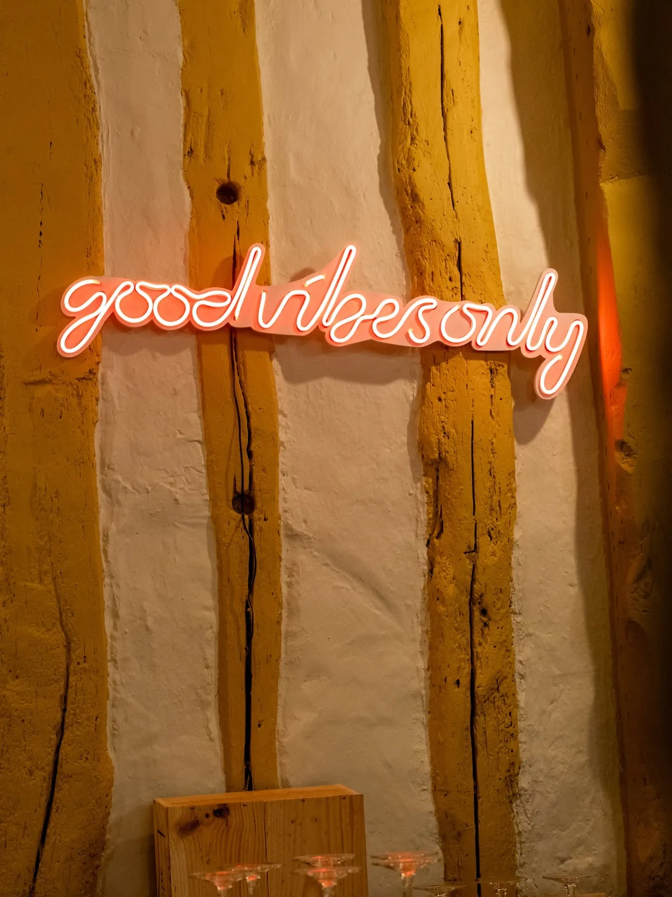 Salle du bar à vin Au 2ème verre à Rouen, avec mur à colombages normands et enseigne lumineuse "good vibes only".