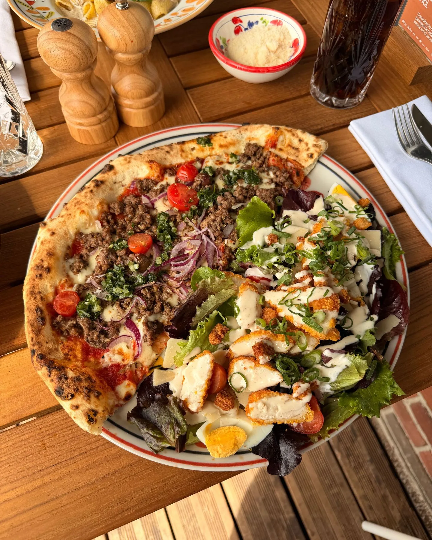 Pizza bolognese cuite au feu de bois et salade César à l'italienne au poulet frit servies en mezza pizza, mezza insalata chez Carla